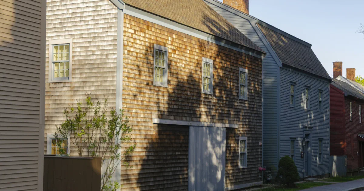 Weathered wooden houses lining a sunny residential street.