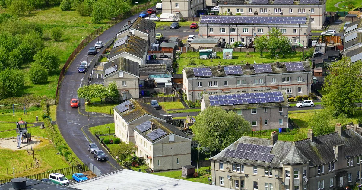 Aerial view of a residential neighborhood with solar panels on many rooftops.